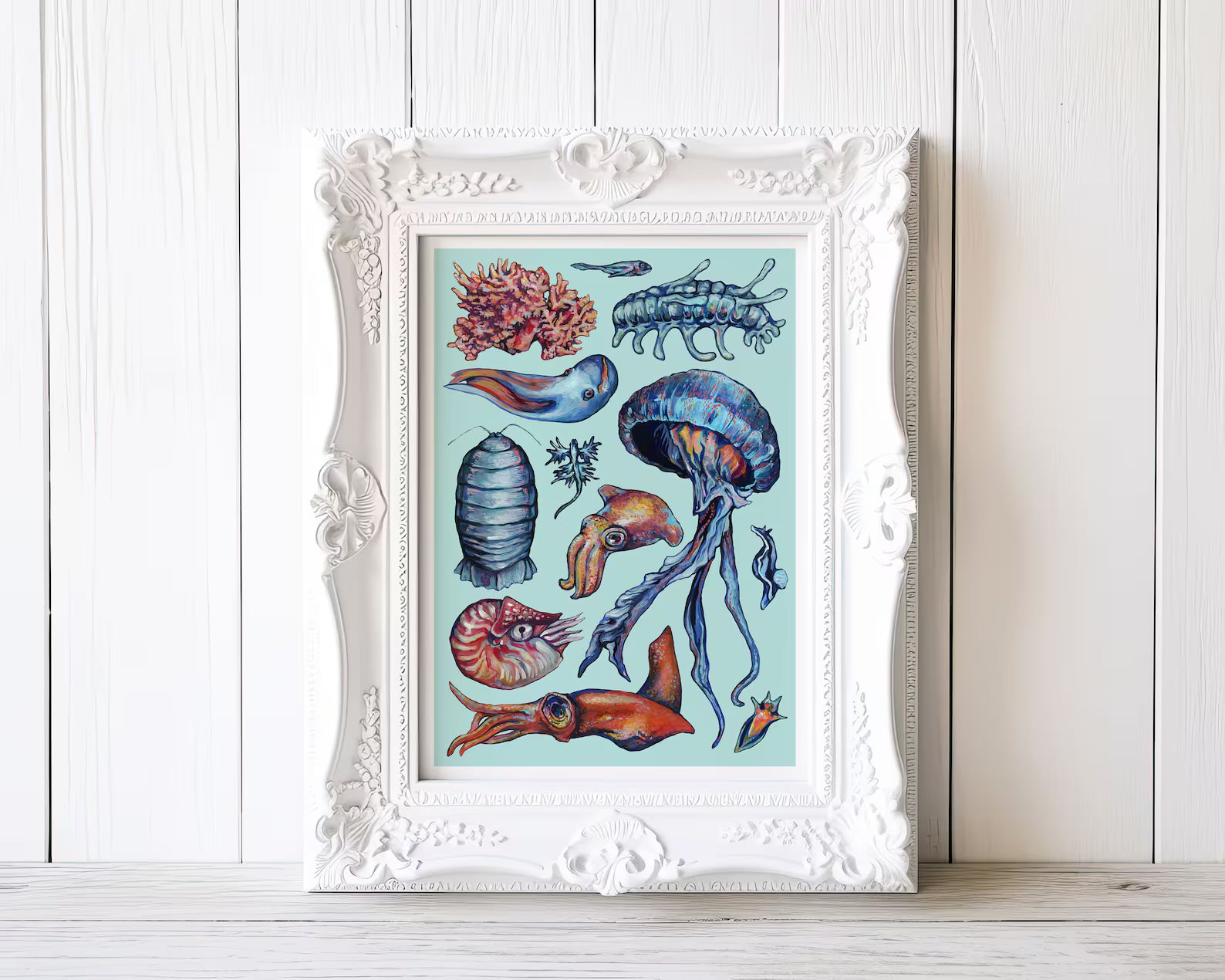 Framed artwork of marine life on a white wooden surface with a light wooden panel background