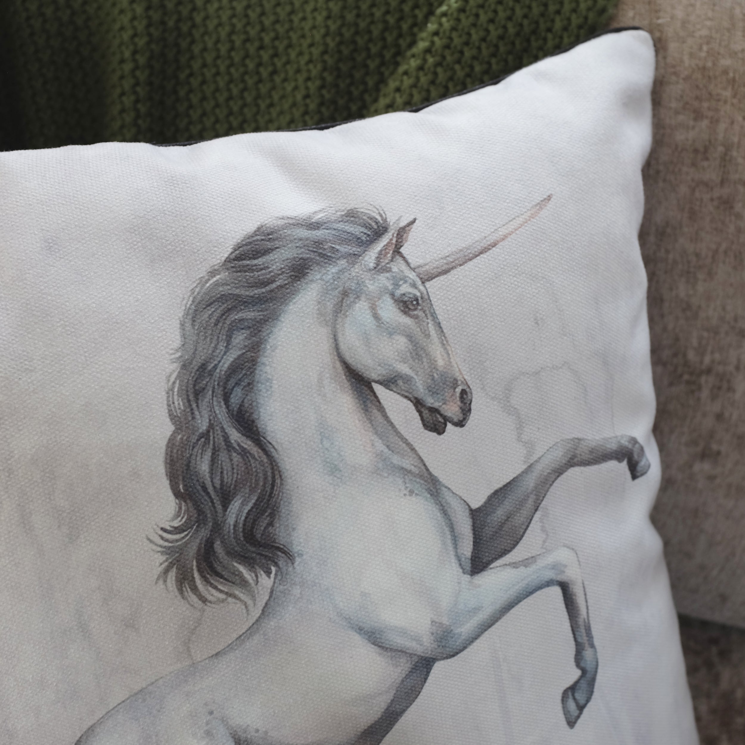 Pillow with a unicorn illustration on a neutral background