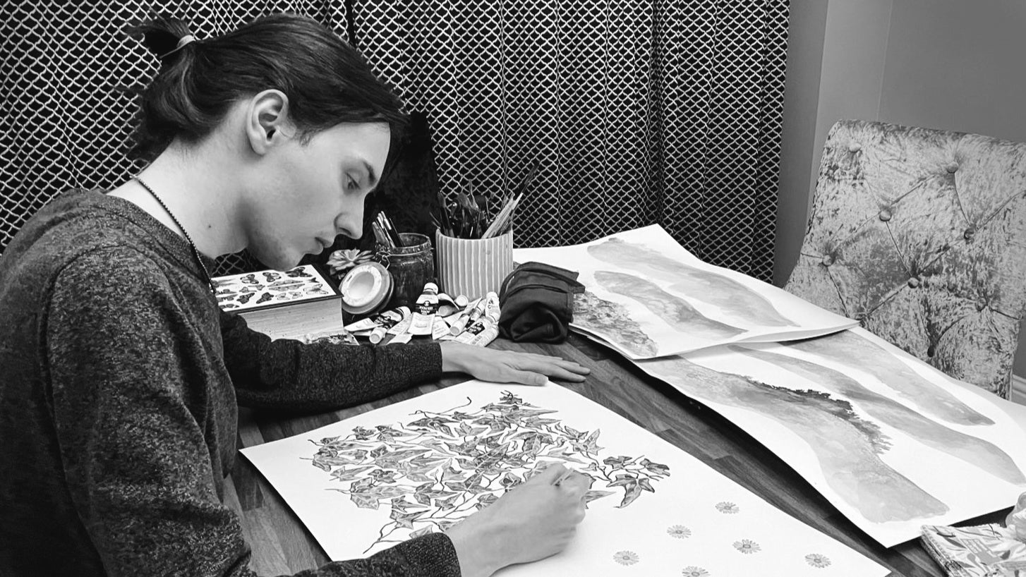 Person working on detailed artwork with various materials in a studio setting